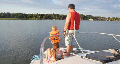 Man and child fishing on a boat in the Mecklenburg Lake Plateau